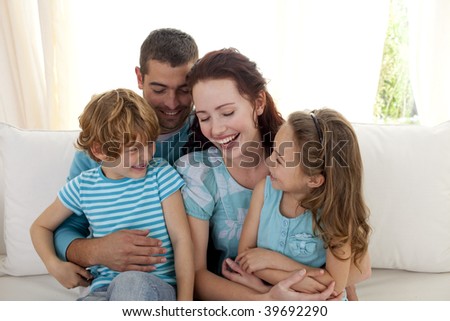 Family in living-room sitting on sofa having fun together