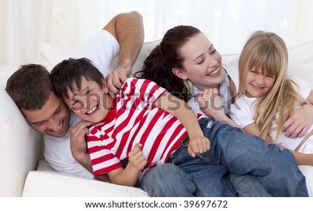 Family in living-room playing on sofa together