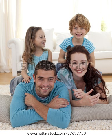 Parents, daughter and son lying on floor in living-room