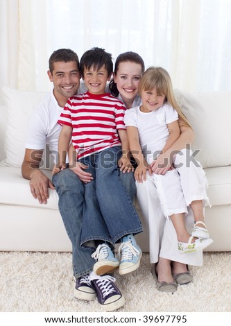 Family in living-room sitting on sofa together