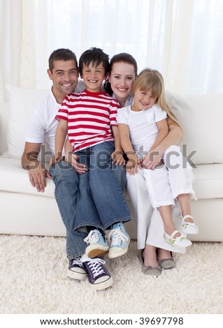 Smiling family in living-room sitting on sofa together