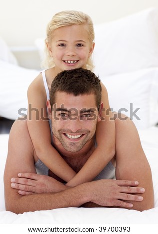 Happy father and doughter playing under the bedsheets