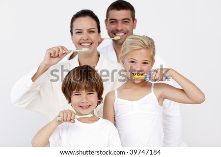 Happy family cleaning their teeth in bathroom