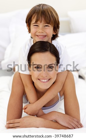 Happy son hugging his mother in bed