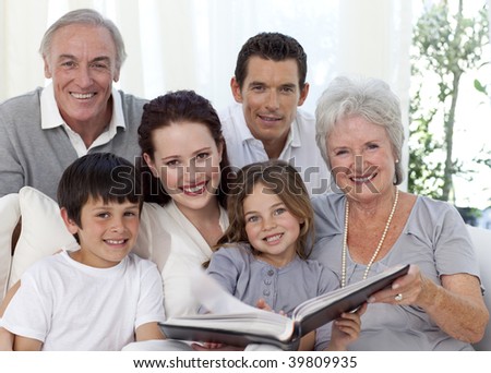 Smiling family looking at a photograph album at home