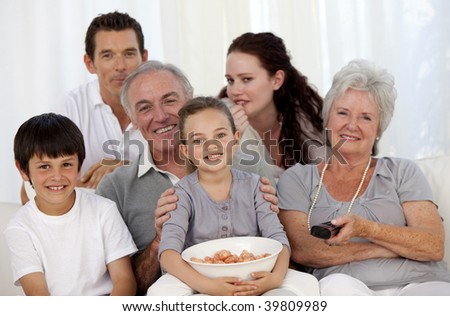 Happy family eating chips and watching television