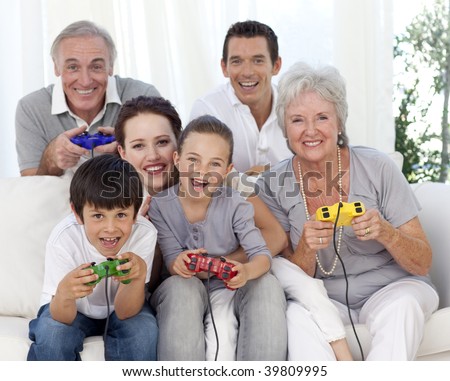 Grandparents, parents and children having fun playing video games