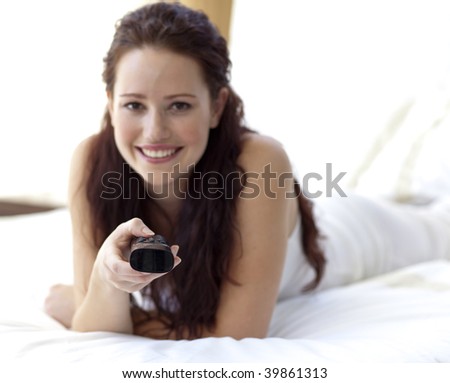 Beautiful woman in bed holding a remote control