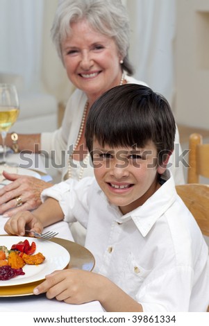 Smiling boy having dinner with his family at home