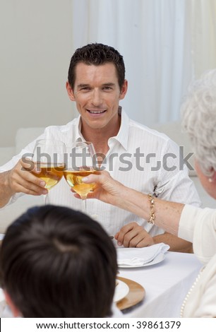 Attractive man toasting with his mother in a Christmas dinner