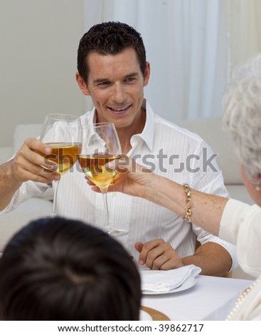 Man toasting with his mother in a Christmas dinner at home