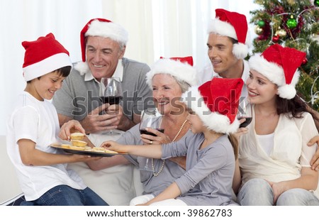 Family drinking wine and eating sweets in Christmas at home