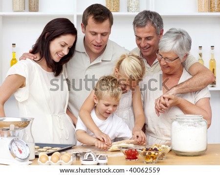 Brother and sister baking in the kitchen with their grandparents and parents