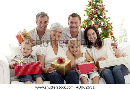 Happy family holding Christmas presents at home
