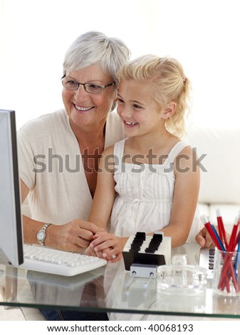 Granddaughter and grandmother using a computer at home