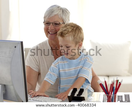 Grandson and grandmother using a computer at home