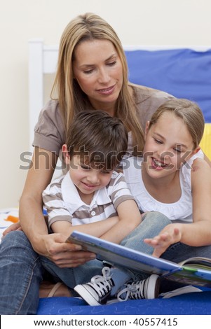 Mother reading a book with her daughter and son in bedroom