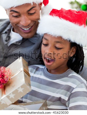 Portrait of a happy Afro-American father and son opening a Christmas gift