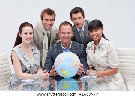 Business team holding a terrestrial globe in the office. Global business concept