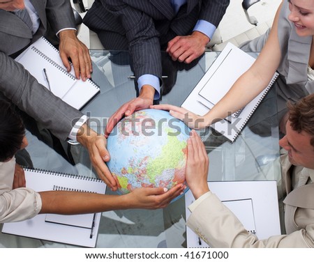 High angle of business team holding a terrestrial globe. Global expansion