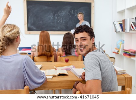 Teenager asking a question to a friend in the class