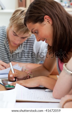 Teen girl studying in the library with her friends. Concept of education
