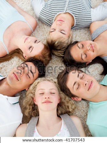 Friends with their heads together sleeping on the ground at home