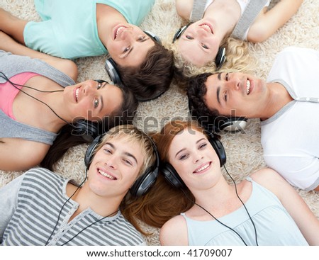 Group of young friends listening to music on the floor