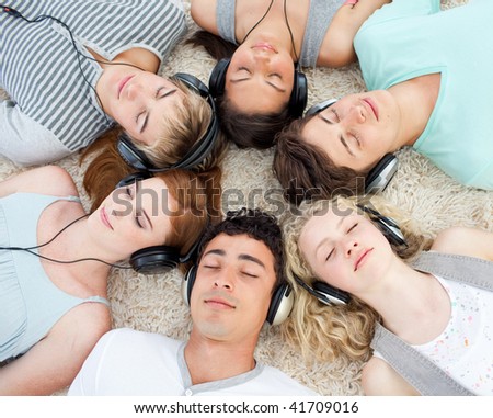 Group of young friends listening to music on the floor