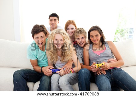 Teenagers having fun playing video games in the living-room