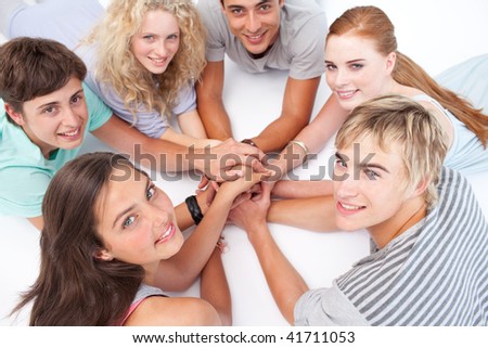 Smiling Teenagers lying on the floor in a circle playing hands games