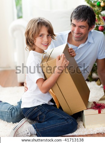 Happy Father and his son opening Christmas gifts at home