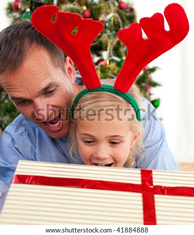 Father and his daughter opening Christmas gifts at home