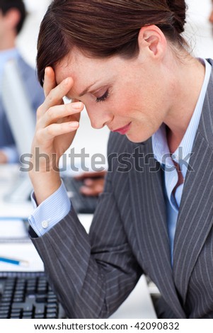 Beautiful businesswoman suffering from a headache in the office