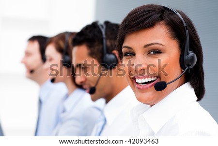 Attractive young woman working in a call center with his colleagues