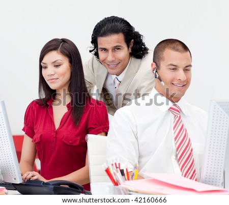 Attractive manager checking his team work in the office