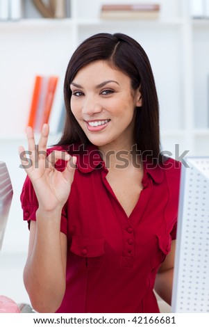 Ethnic businesswoman showing OK sign at work