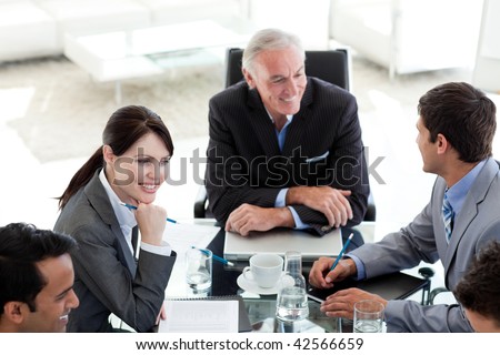 International business people discussing a business plan sitting around a conference table