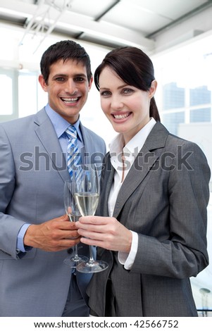 Two smiling colleagues drinking Champagne to celebrate a success