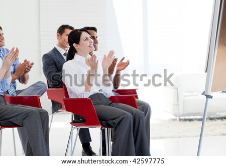 Multi-ethnic business people clapping at the end of a conference in the office