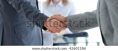 Close-up of businessmen shaking hands in an office