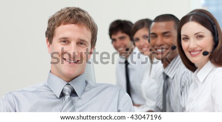 Manager and his team smiling at the camera in a call center