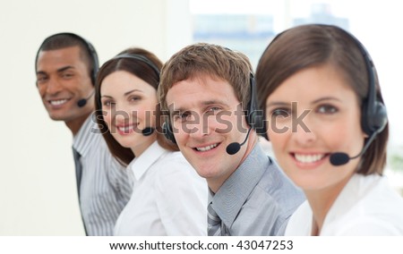 Smiling customer service agents with headset on in a call center