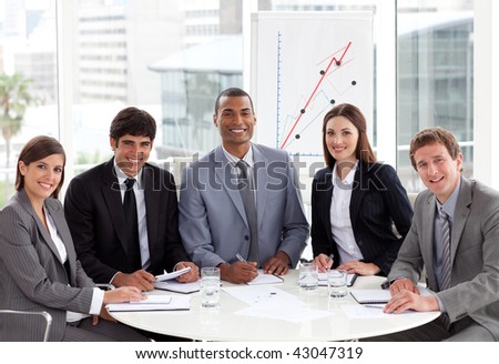 Multi-ethnic business team in a meeting smiling at the camera