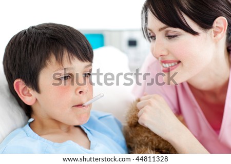 Smiling nurse taking her patient\'s temperature in a hospital
