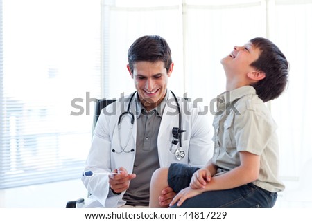Smiling doctor checking a child\'s reflex during a medical visit