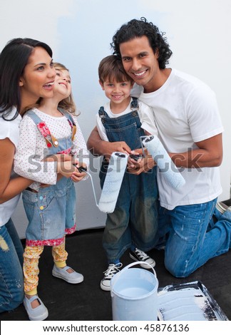 Cute children painting a room with their parents in their new house