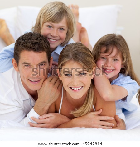 Happy family having fun together lying on a bed