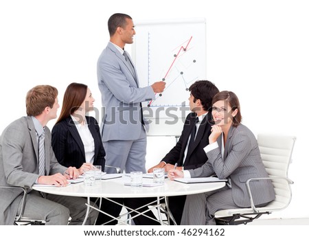 Self-assured businessman reporting sales figures to his team