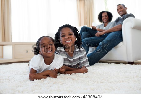 Smiling brother and sister lying on the floor  in the living room